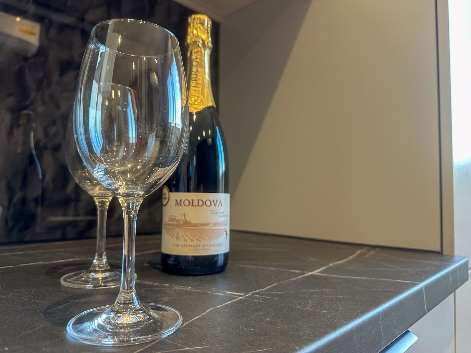 Wine glasses and a bottle of Moldovan sparkling wine on the kitchen counter